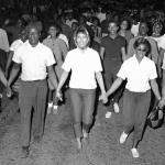 Cambridge residents begin protest of segregationists George Wallace who speaking to an all-white crowd nearby.

