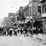 12th Street looking south towards the boulevard. As daylight broke, this was the scene that greeted Detroit police when they returned to the area. A holiday of piracy ensued. 12th Street would soon be on fire. The Supreme Linoleum & Paint Company on the right would burn for days.